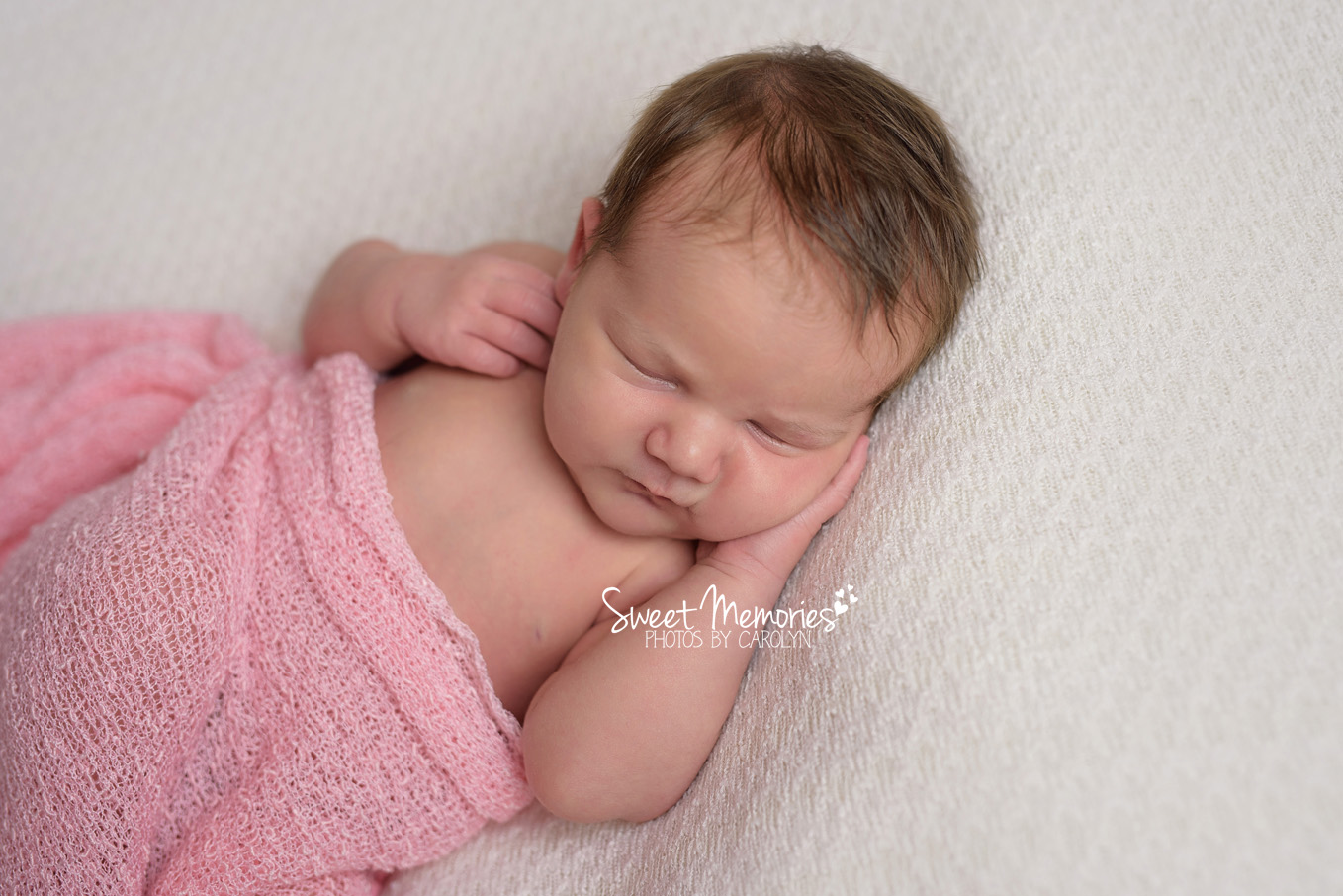newborn girl with pink wrap