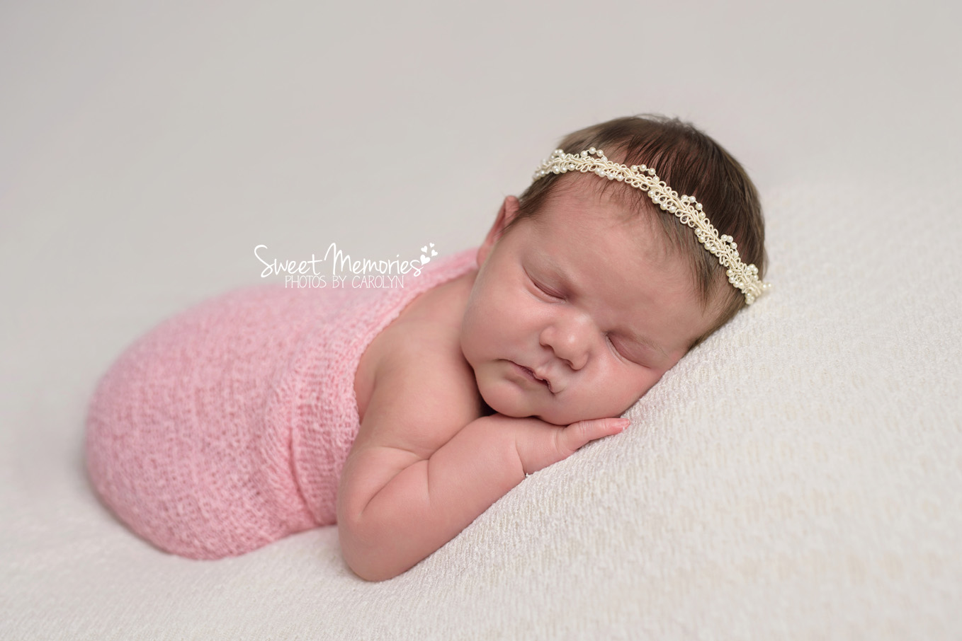 newborn girl with pink wrap and headband