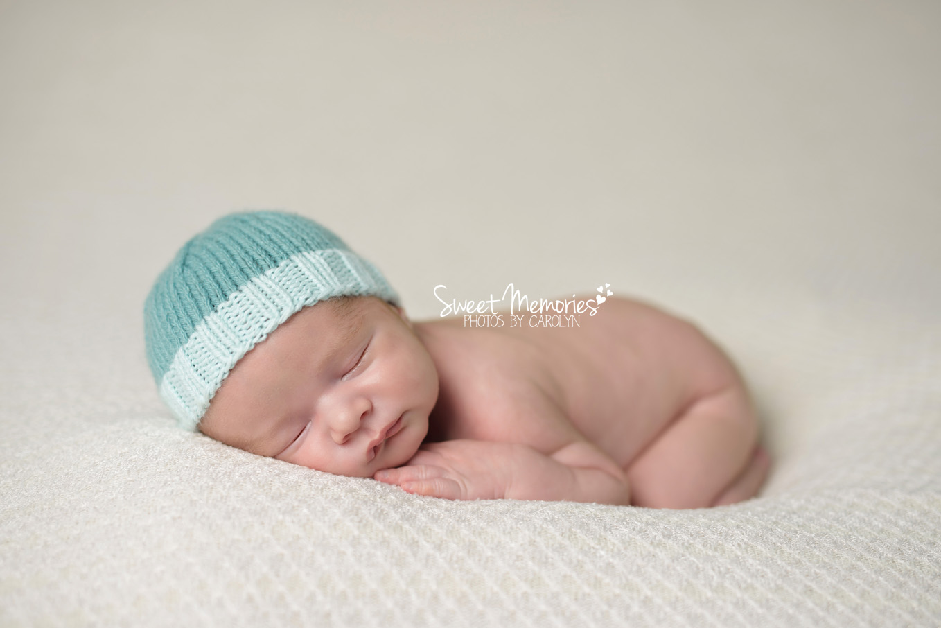 newborn boy in teal hat