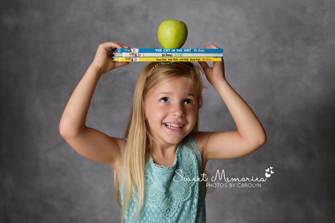 cute girl balancing books on her head to celebrate going back to school | King of Prussia PA photographer