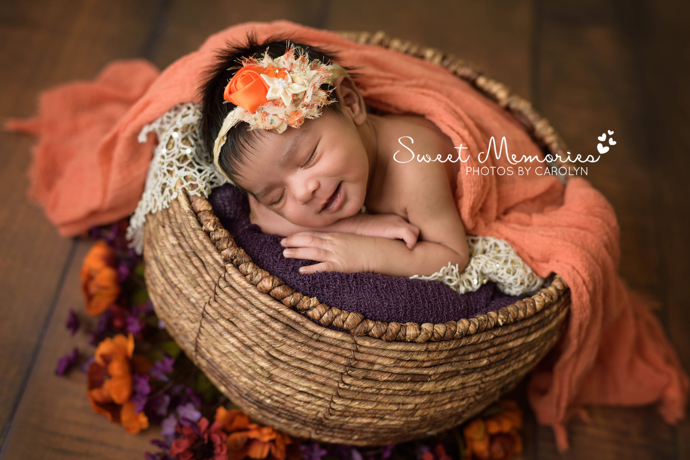 Sweet Memories Photos by Carolyn | Newtown PA | Bucks County Montgomery County Newborn Infant Baby Photographer | Indian newborn baby girl smiling in basket | purple orange gold fall flowers