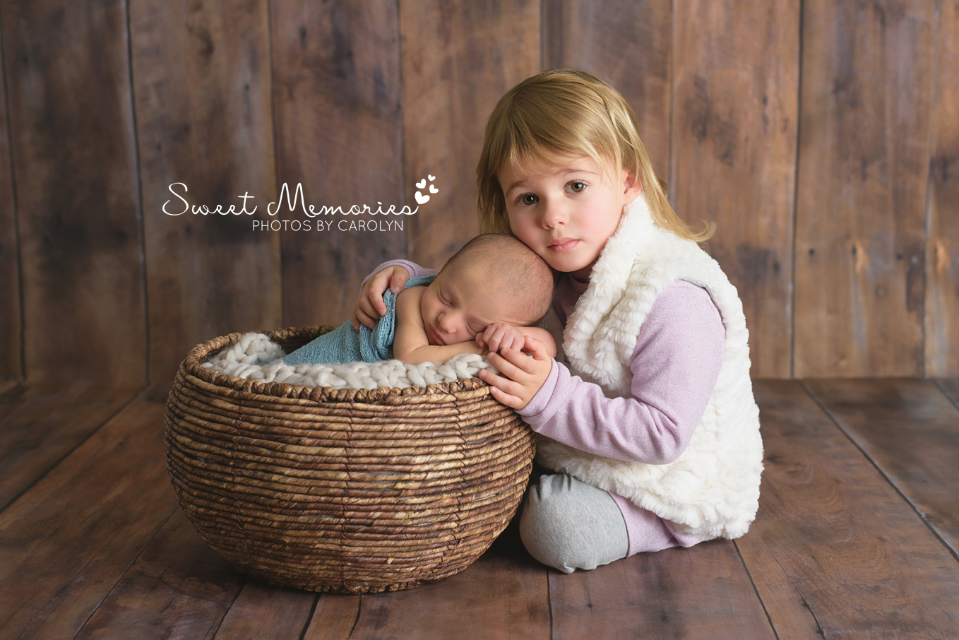 newborn boy in basket with big sister sitting on wood backdrop | Sweet Memories Photos by Carolyn