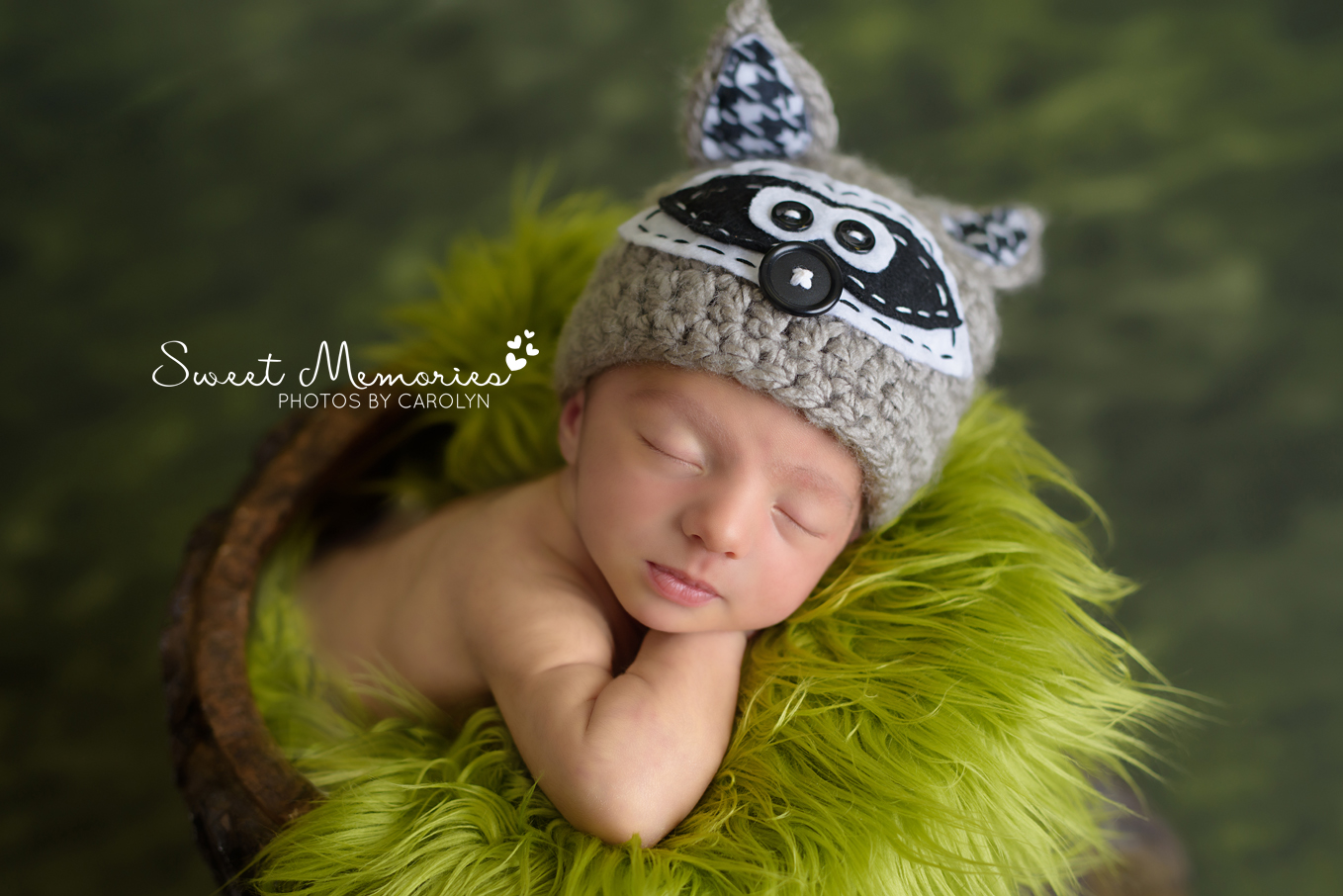 newborn boy sleeping with raccoon hat