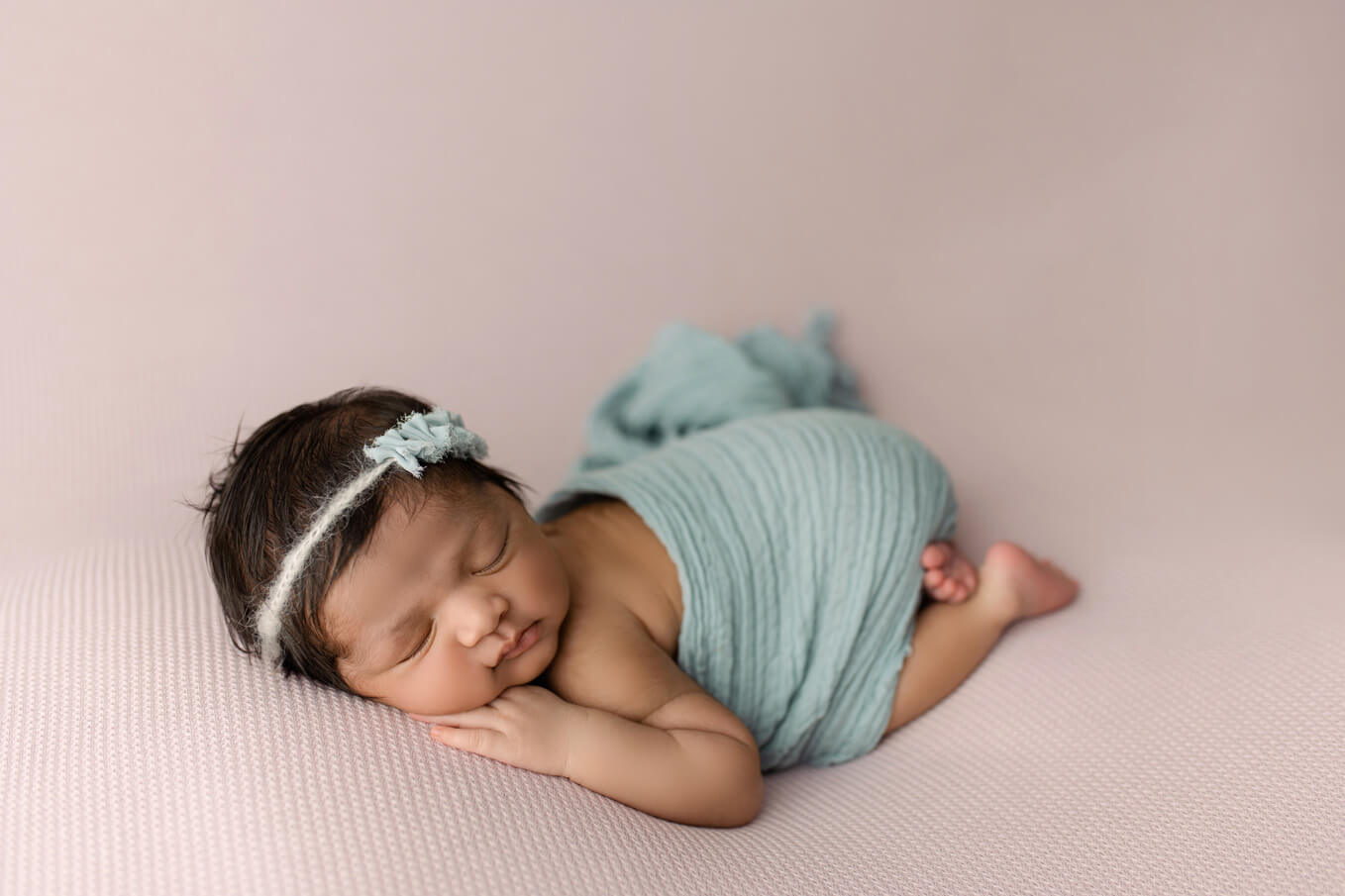 how to choose a newborn photographer | baby girl with blue wrap on purple blanket