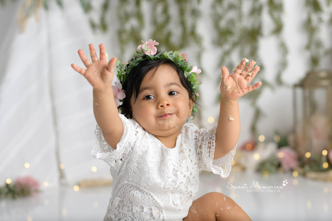 one year old baby girl with hands up on boho floral backdrop | Austin cake smash photography
