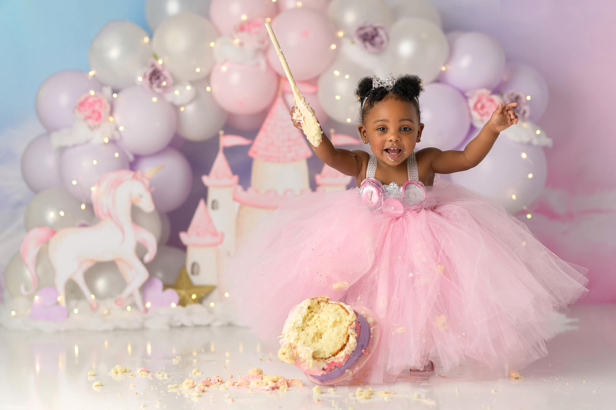 Baby girl knocking over cake at princess themed first birthday cake smash with Sweet Memories Photos by Carolyn